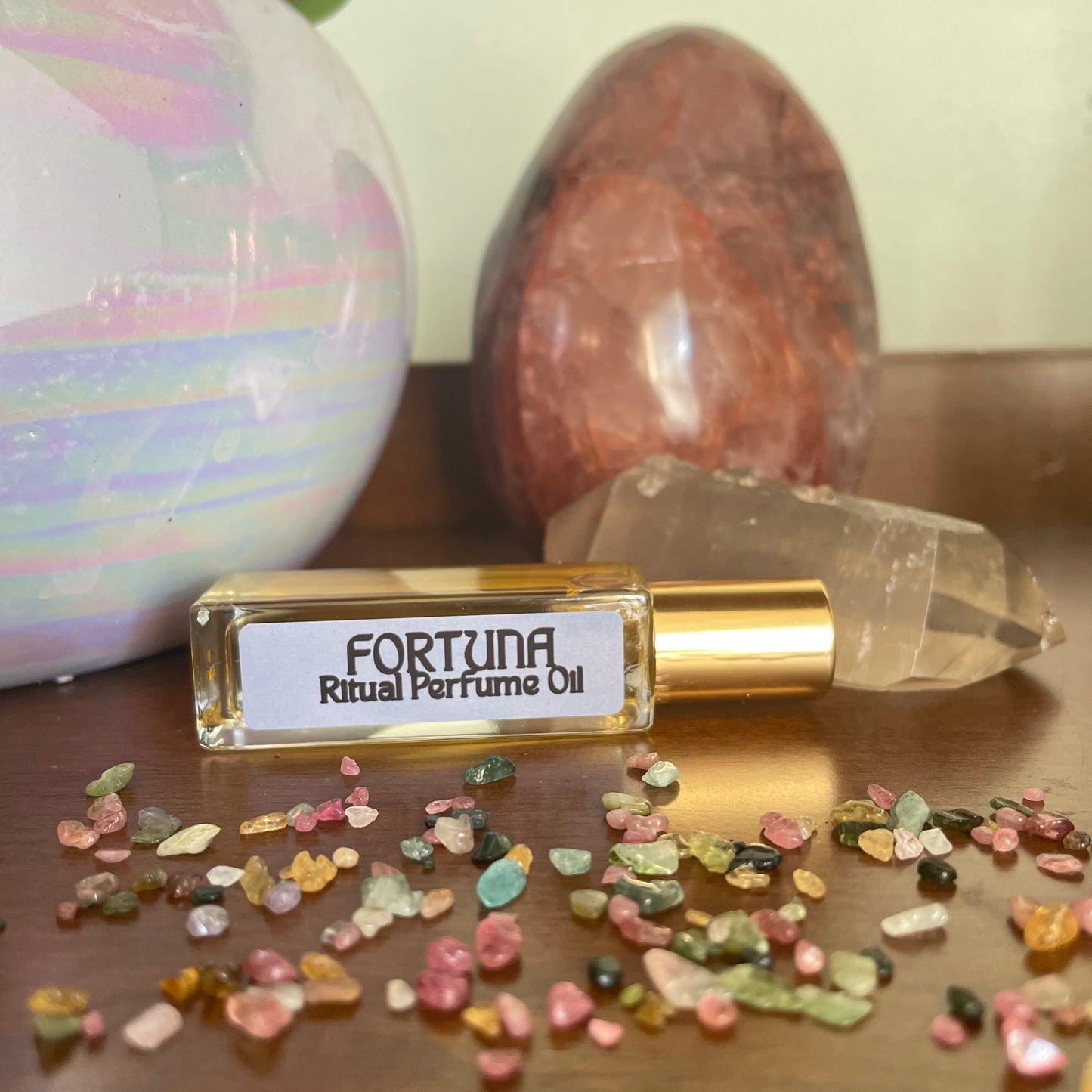 Fortuna Ritual Perfume Oil bottle with crystals and stones on a wooden surface