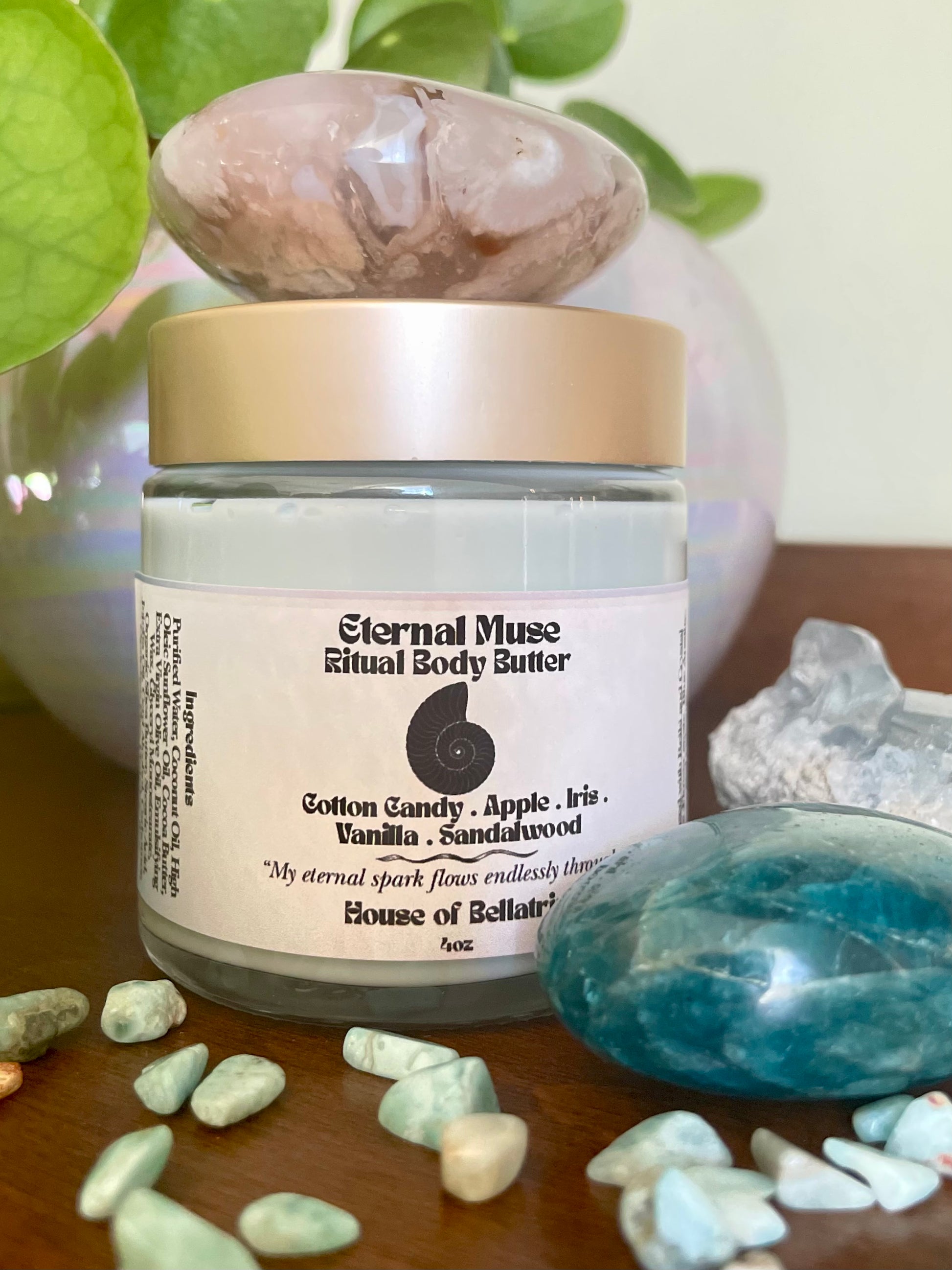 Jar of Eternal Muse Ritual Body Butter with decorative stones and crystals on a wooden surface