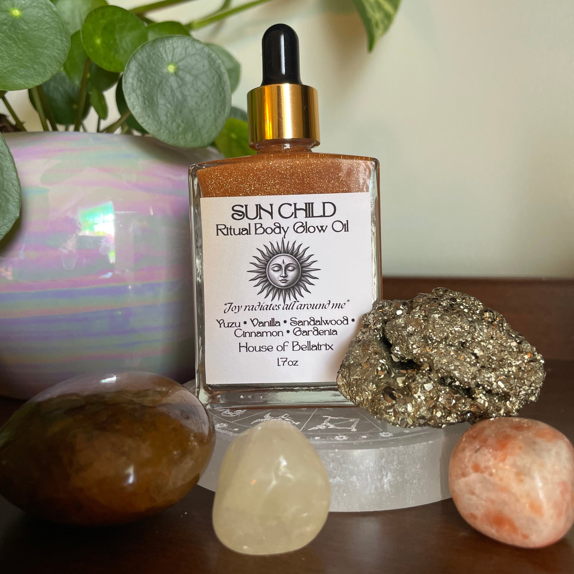 Bottle of Sunchild Radiance Glow Oil with crystals and plants in the background